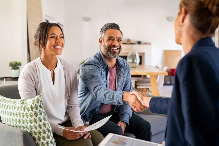 Agent shaking hands with a smiling couple